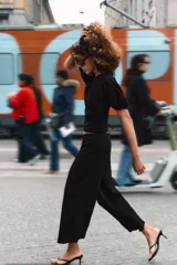Pantalón de tiro medio con pierna ancha, confeccionado en tejido de algodón. Presenta falsos bolsillos de vivo en el delantero y cierre con cremallera oculta en la costura.