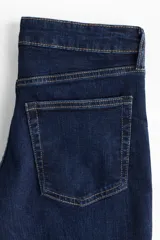 Jean de corte bootcut con cinco bolsillos, confeccionado en denim azul oscuro con leve stretch. Presenta cintura clásica, cierre con botón y raya planchada tanto en la parte frontal como trasera.