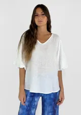 Blusa blanca de lino con escote en V y mangas cortas amplias.