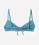 Top de bikini bandeau celeste con acabado satinado, breteles finos y un llamativo aplique metálico dorado en el centro.
