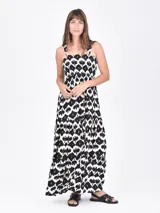 Vestido largo de tirantes con diseño de volados en la falda y estampado geométrico en tonos blanco, negro y toques de marrón.