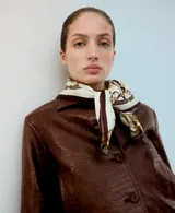 Chaqueta marrón efecto cuero con textura, cierre frontal con botones y puños y cintura elásticos tejidos.