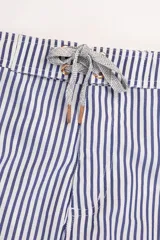 Short de baño con rayas verticales azules y blancas, pretina elastizada con cordón ajustable, bolsillos laterales y traseros con cierre.
