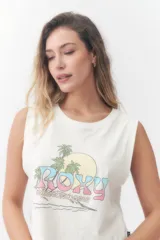 Musculosa Roxy color crudo, con cuello redondo y diseño sin mangas con sisas amplias. Presenta un estampado frontal con la palabra 'Roxy' en tonos degradados de rosado y celeste, acompañado de palmeras, un sol y la leyenda 'Sunsets Chaser'.