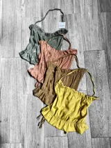 Top con breteles finos y volados en el ruedo, disponible en varios colores.