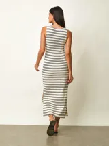 Vestido midi de punto a rayas horizontales negras sobre fondo blanco, con cuello redondo, sin mangas y tajo lateral en el dobladillo.