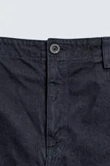 Bermuda de corte relajado confeccionada en denim de algodón rígido, con pliegues frontales, bolsillos laterales y bolsillos traseros de vivo. Cuenta con cierre frontal de cremallera y botón.