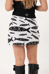 Minifalda blanca con estampado de peces negros, de silueta recta.