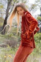 Blazer de terciopelo color terracota, con cuello solapa, cierre con botón de guampa y detalles en cuero. Corte entallado.