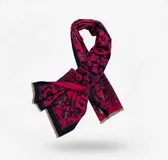 Pashmina rectangular de textura suave con diseño estampado en tonos fucsia y azul, con bordes desflecados.