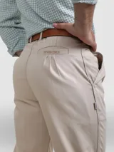 Pantalón de vestir azul marino, de corte recto, con bolsillos laterales y traseros. Se ajusta a la cintura con cinturón de cuero marrón.