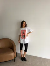 Remerón de algodón blanco con corte oversize y cuello redondo, que presenta un estampado frontal con diseño de una lata de sardinas sobre fondo de rayas.