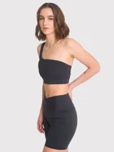 Top deportivo de un solo hombro, color negro, con diseño de tirantes triples elásticos en la espalda y almohadillas removibles.