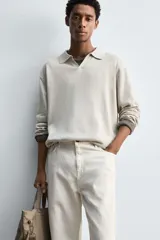 Polo de punto regular fit en color beige, confeccionado con una mezcla de algodón y cáñamo. Presenta cuello solapa con abertura frontal, manga larga y acabados en rib.