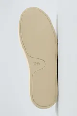 Mocasín casual de cuero negro con detalle de costuras en el empeine y suela de goma color crema.