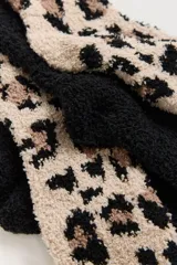 Pack de dos pares de medias de textura afelpada y suave. Incluye un par liso en color negro y un par con estampado animal print en tonos beige y negro.