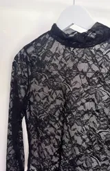 Top de encaje negro con cuello alto y mangas largas.