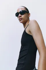 Camiseta ajustada negra con escote redondo y tirantes finos.