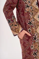Saco largo abierto con diseño estampado estilo paisley y motivos florales en tonos bordó, negro y beige. Presenta un corte recto y mangas largas.