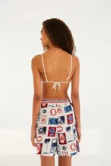 Bermuda blanca con estampado de motivos turísticos de Brasil en tonos rojo y azul.
