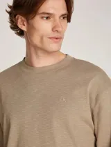 Remera de manga larga color beige, de tejido slub con textura rústica. Tiene cuello redondo y puños con elástico.