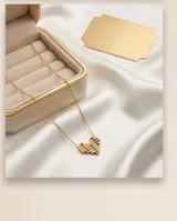 Collar de acero con baño de oro, compuesto por una cadena fina y un dije en forma de corazón con diseño pixelado, adornado con circonias de colores.