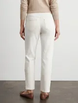 Pantalón tipo jegging de denim color blanco roto, tiro alto, corte recto al tobillo con cierre funcional en el ruedo. Diseño pull-on sin cierre ni botón frontal, con bolsillos funcionales traseros y simulados delanteros.