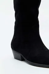Bota alta de gamuza color beige, estilo texana, con taco cuadrado y puntera fina.
