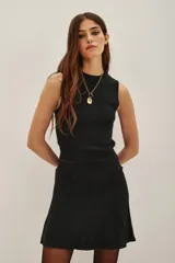 Top sin mangas con cuello halter, confeccionado en tejido de punto con acabado metalizado. Presenta un ajuste al cuerpo y diseño minimalista.