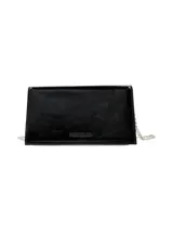 Cartera de mano rígida color negro charol con cadena plateada removible.