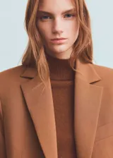 Blazer estructurado de corte recto, con cuello de solapa con muesca, cierre frontal de un botón y bolsillos laterales con solapa.