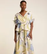 Vestido evasê midi de viscolino con estampado floral, escote en V cruzado, mangas cortas con lazos y corte en la cintura.
