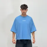 Remera de corte boxy fit color beige, con estampa gráfica en la espalda en color marrón que incluye el logo de la marca y texto descriptivo.