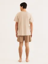 Pijama de hombre compuesto por una remera de manga corta color verde oliva con una línea horizontal negra y un pequeño logo en forma de 'x' en el pecho, y un short negro liso.