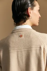 Cardigan de tejido de punto color rojo, con cuello redondo, cierre frontal de botones al tono y puños acanalados.