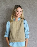 Chaleco de corte recto y largo a la cintura, confeccionado en denim con estampado de rayas verticales en tonos azul y blanco. Presenta cuello redondo y costuras visibles que definen su estructura.