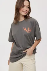 Remera de manga corta con calce oversized y cuello redondo, color gris oscuro, con pequeño gráfico de rayos naranjas en el frente.