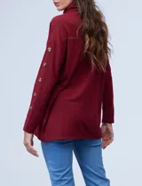 Polera negra de tejido soft con cuello alto y mangas largas con aplique de botones.