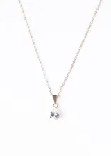 Collar dorado con cadena fina y dije de zirconia blanca en forma de lágrima.
