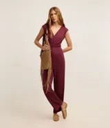 Mono largo de viscosa color borgoña, con corte flare, escote en V, sin mangas, elástico en la cintura y lazo en el cuello.