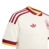 Camiseta de fútbol Adidas de la segunda equipación de la selección de España, color blanco con detalles en bordó y amarillo en cuello, hombros y mangas. Incluye el logo trébol de Adidas y el escudo de la selección bordados en el pecho.
