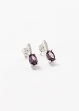 Par de caravanas colgantes de plata 925 con zirconia oval violeta y detalles de circonitas blancas.
