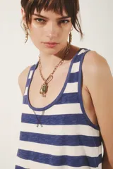 Musculosa de algodón con cuello redondo y escote en U, con diseño de rayas horizontales azules y blancas. Presenta un detalle de costura en forma de 'X' en el escote.