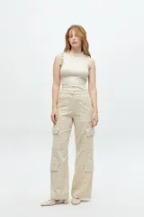 Pantalón cargo color beige con calados, de tiro medio, corte recto y bolsillos laterales con solapa.
