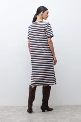 Vestido midi de manga corta con estampado de rayas horizontales en tonos azul marino, blanco y marrón. Presenta cuello redondo y una abertura lateral en el ruedo.