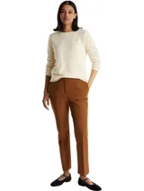 Sweater de lana de corte regular con cuello redondo y mangas largas. Presenta un diseño minimalista en color beige con el logo de la marca bordado en el pecho.