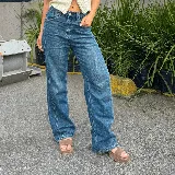 Sandalia de cuero vacuno color negro, con taco ancho de 7 cm y plataforma de 2 cm. Diseño de punta cuadrada, con tira ancha en el empeine y tira ajustable con hebilla en el tobillo.