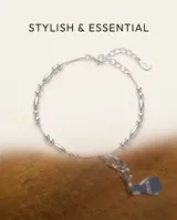 Pulsera de plata fina con abalorios de cuentas esféricas y cilíndricas intercaladas a lo largo de la cadena.