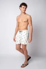 Short de baño color crema con estampado de cangrejos pequeños, cintura elástica con cordón ajustable y etiqueta con logo en el ruedo.