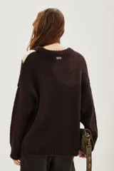 Sweater de punto con diseño de rayo en color crema sobre fondo marrón oscuro, de corte holgado, cuello redondo y mangas largas con puños acanalados.